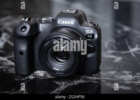 Modern digital mirrorless camera. Canon's new mirrorless camera close-up. Mirrorless Camera Canon Eos R6 with RF 50 mm lens on dark background-Danang Stock Photo