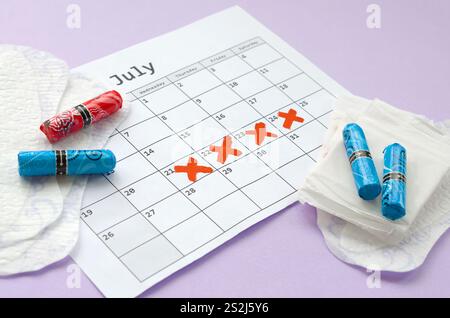 Aspects of women wellness in monthlies period. Menstrual pads and tampons on menstruation period calendar. Woman critical days, gynecological menstrua Stock Photo