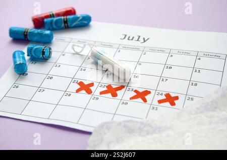 Aspects of women wellness in monthlies period. Menstrual pads and tampons on menstruation period calendar. Woman critical days, gynecological menstrua Stock Photo