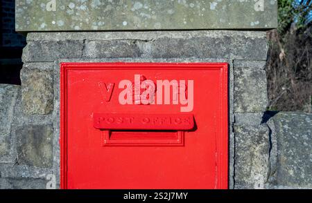 Red Victorian wall-mounted post box situated outside Haworth station. Stock Photo
