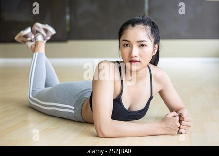 Women lie down, relax and lift their legs in the gym. Stock Photo