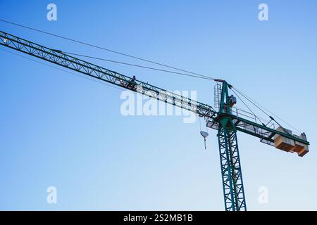Construction tower crane isolated on blue sky with white clouds background Stock Photo