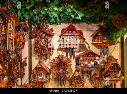 Rothenburg ob der Tauber, Germany - August 8, 2024: A collection of intricately designed wooden cuckoo clocks displayed on a wall, featuring various s Stock Photo