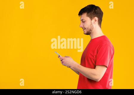 Portrait of young guy using mobile phone, side view Stock Photo