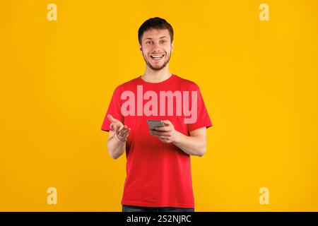 Smiling young man using mobile phone at studio Stock Photo