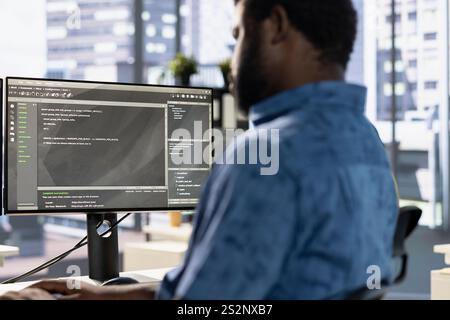 System administrator debugging company software to minimize occurrence of bugs, identifying bottlenecks. African american man writing clean, efficient code in programming language to reduce errors Stock Photo