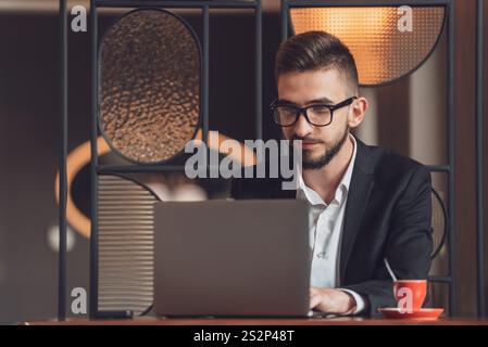 A young business man working on a laptop in the office. Stock Photo