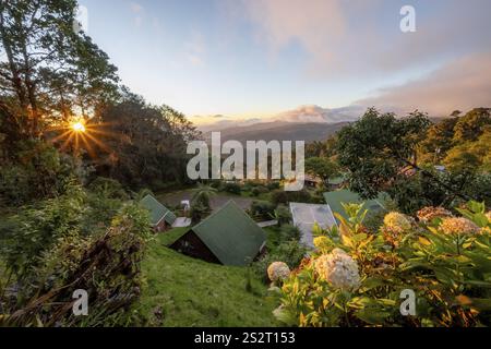 Cabins of a lodge in the cloud forest, in the evening light, Paraiso Quetzal Lodge, view over mountain landscape, sun star, San Jose province, Costa Stock Photo