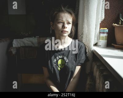 Alina, 15 years old, in the kitchen of the flat where she lives with her siblings, her mother and her stepfather. Ukrainsk is very close to the front Stock Photo
