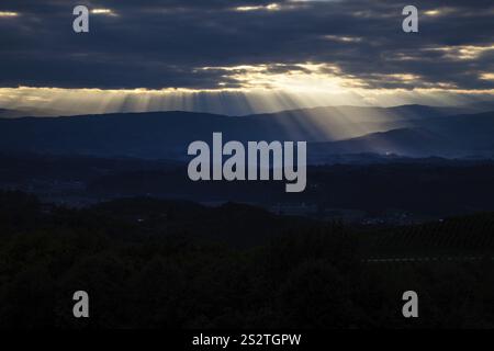 Rays of sunshine break through the cloud cover over a mountain landscape Austria Stock Photo