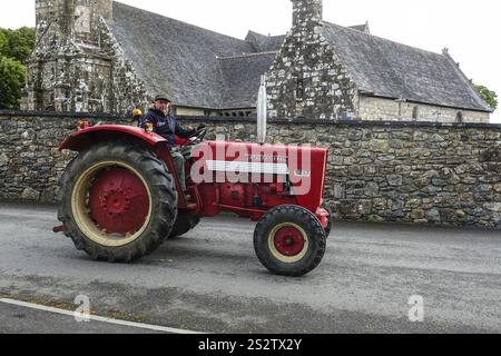 Old tractor Mc Cormick International 523 in front of church and chapel Sainte Nonne, vintage car meeting Dirinon, department Finistere Penn ar Bed, re Stock Photo