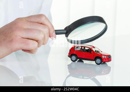 A model of a car is examined by a doctor. Symbol photo for workshop, service and car purchase. Austria Stock Photo