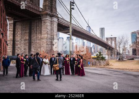 Brooklyn, NY USA - January 27, 2018: Winter wedding party under the Manhattan Bridge in DUMBO Brooklyn. Stock Photo