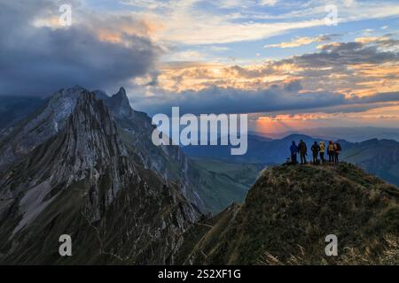 Schaefler, Switzerland - September 29.2023: Hikers standing on the hill top waiting for the sunset at the most spectacular mountain summet in Alpenste Stock Photo