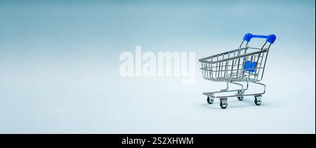 Mini shopping cart or supermarket trolley on blue background Stock Photo