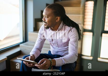 Happy young African American business man using online app on tablet for job communication Stock Photo
