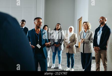A confident CEO leads a successful staff training workshop, encouraging teamwork and collaboration among his diverse team in a modern office environme Stock Photo
