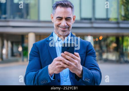 Confident businessman using smartphone outdoors Stock Photo
