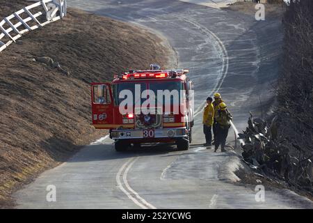 LOS ANGELES COUNTY, CALIFORNIA, USA - 13 December 2024 - Cal Fire firefighters spray water on part of a burning canyon in Los Angeles County, Californ Stock Photo