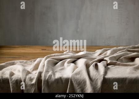 empty rustic wooden table and linen tablecloth on a gray wall background Stock Photo
