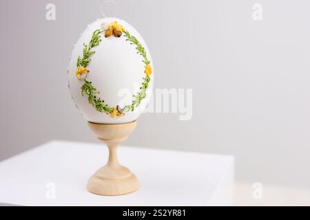 White Easter eggs made with decoupage technique with floral motifs and a flowering branch on a black rustic background. High quality photo Stock Photo