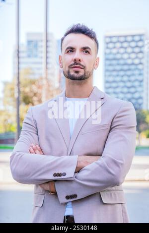 Vertical portait Confident young businessman with arms crossed outdoors Stock Photo
