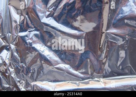 Crumpled reflective shiny gift wrapping material texture background Stock Photo