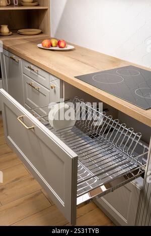 A clean and organized kitchen setup featuring a chrome dish rack with plates and cups. Perfect for showcasing modern kitchen aesthetics and functional Stock Photo