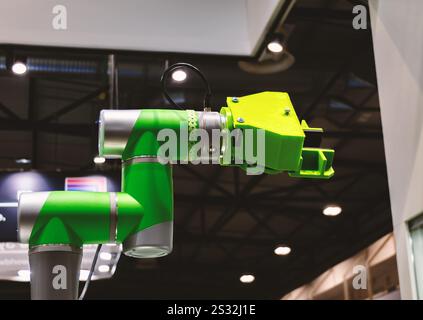 Green collaborative robotic arm in an industrial environment. Stock Photo