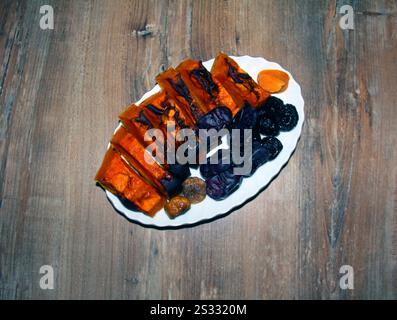 a plate on the table full of pumpkin, prunes, dates and figs Stock Photo