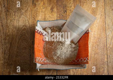 Madagascar Island Gastronomy Still Life. A basket and a bag filled with ground ginger placed on a wooden table Stock Photo