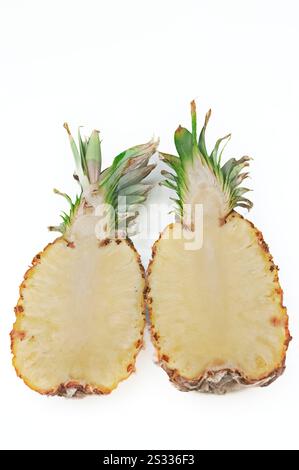 A pineapple cut in half preparing for consumption. Stock Photo