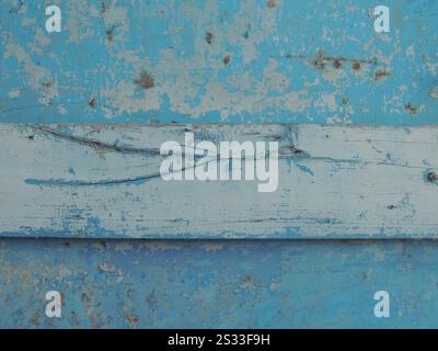 combined texture of cracked dry board and old metal surface, painted with blue paint peeling from aging, fragment of shabby iron door with wood Stock Photo
