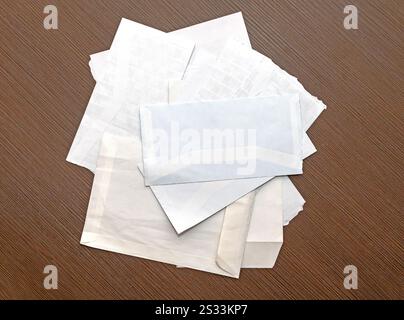 Pile of blank white paper envelopes on wooden table Stock Photo