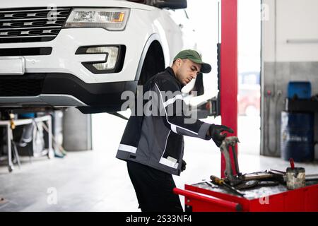 A skilled auto mechanic in a garage working on car repairs, showcasing expertise and focus. The image captures a professional environment dedicated to Stock Photo