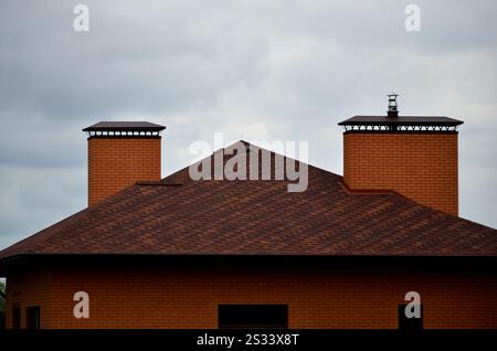 The house is equipped with high-quality roofing of shingles (bitumen tiles). A good example of perfect roofing. The roof is reliably protected from ad Stock Photo