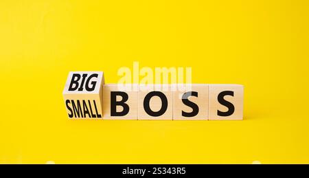 Big vs small boss symbol. Turned wooden cubes with words Small boss and Big boss. Beautiful yellow background. Business concept. Copy space. Stock Photo