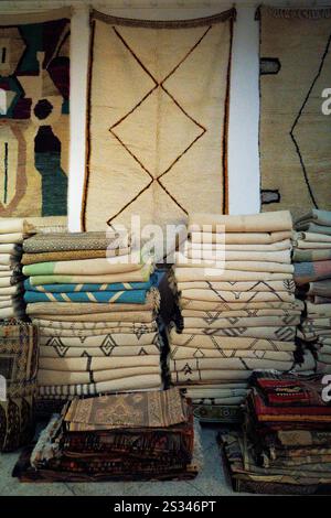 Stacks of handmade Berber rugs for sale in a gallery in Tangier, Morocco, Africa Stock Photo