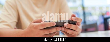 Man playing game on mobile phone. gamer boy playing video games holding Smartphone working mobile devices. cell telephone technology e-commerce concep Stock Photo