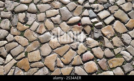 Close-up view of a cobbled stone street in Portugal, showcasing intricate patterns of calçada portuguesa. (Portuguese: "Calçada portuguesa") Stock Photo