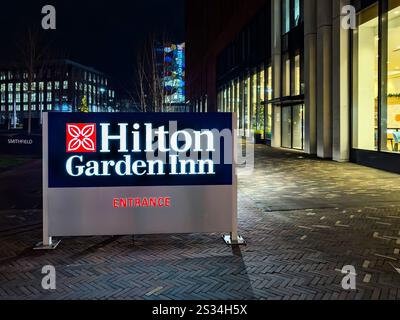 Illuminated sign of Hilton Garden Inn hotel entrance at night outside a modern building with large windows - Hanley stoke on trent Stock Photo