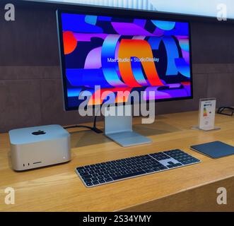 Paris, France - Dec 10, 2024: A sleek Mac Studio setup featuring a vibrant Studio Display, keyboard, and trackpad on a wooden desk. A product information card is also visible. Stock Photo