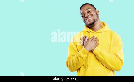 Thankful African Guy Pressing Hands To Chest Over Blue Background Stock Photo