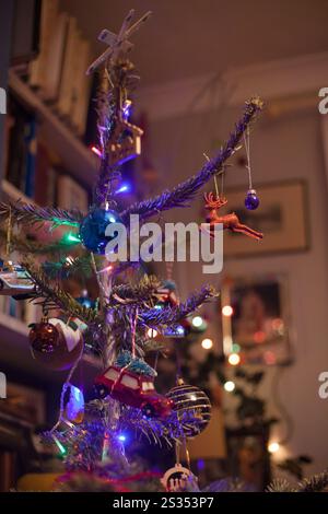 Bright colours colours with Christmas tree lights and baubles decorations on real Christmas tree Stock Photo