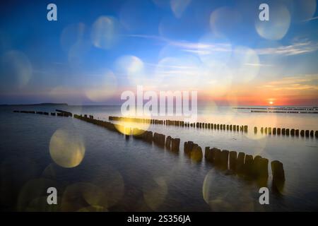 X-buhne abstract, cross-buhne on the Baltic Sea beach Dranske at sunset with light reflections, golden hour, Baltic Sea, Baltic Sea island, Rügen, Ger Stock Photo