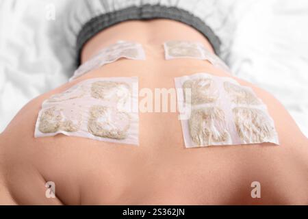 Sick young man with mustard plasters lying on bed, closeup Stock Photo