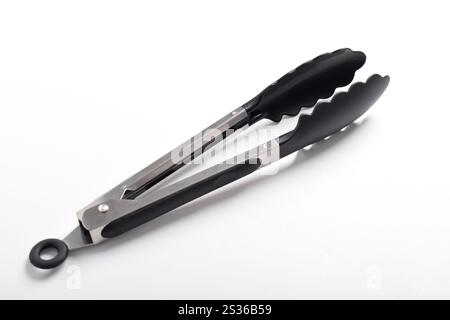 Kitchen tongs isolated on white background. Steel kitchen tongs with heat resistant silicone tips. Stock Photo