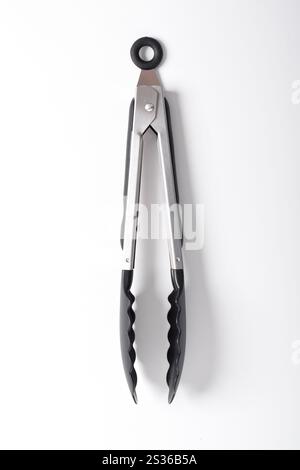 Kitchen tongs isolated on white background. Steel kitchen tongs with heat resistant silicone tips. Stock Photo