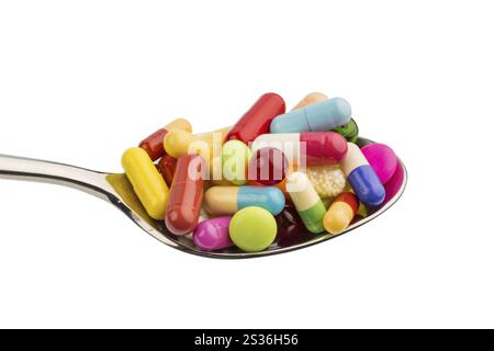 Many colourful tablets on a spoon. Symbolic photo for tablet addiction and misuse of medication. Austria Stock Photo