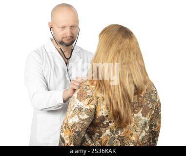 A male doctor in a white coat is using a stethoscope to examine a female patient’s back. Stock Photo